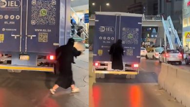 امرأة تتشبث بحافلة تسير على الطريق في بطحاء الرياض .. فيديو